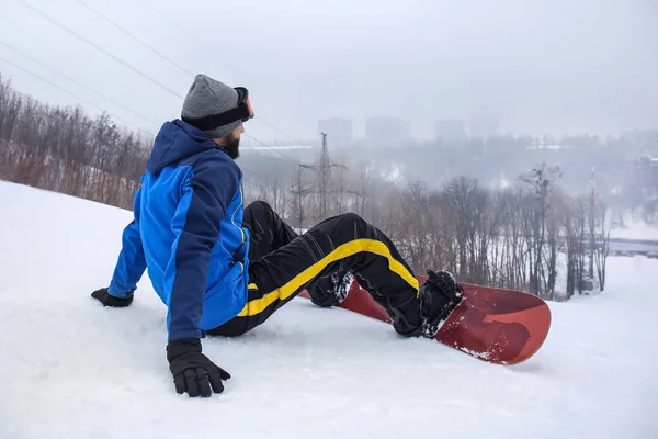 Αρσενικό snowboarder σε πλαγιά στο χειμερινό θέρετρο — Φωτογραφία Αρχείου