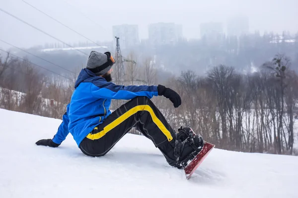 Αρσενικό snowboarder σε πλαγιά στο χειμερινό θέρετρο — Φωτογραφία Αρχείου