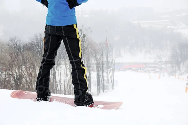 Αρσενικό snowboarder σε πλαγιά στο χειμερινό θέρετρο — Φωτογραφία Αρχείου