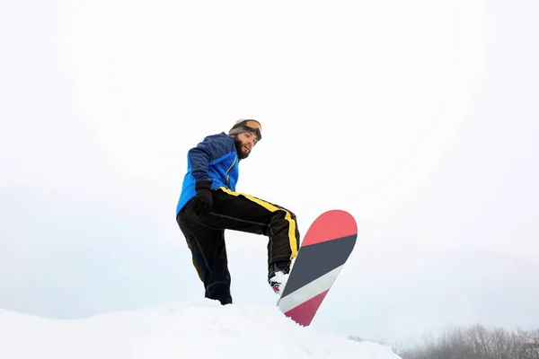 Snowboarder maschio su pendio in località invernale — Foto Stock
