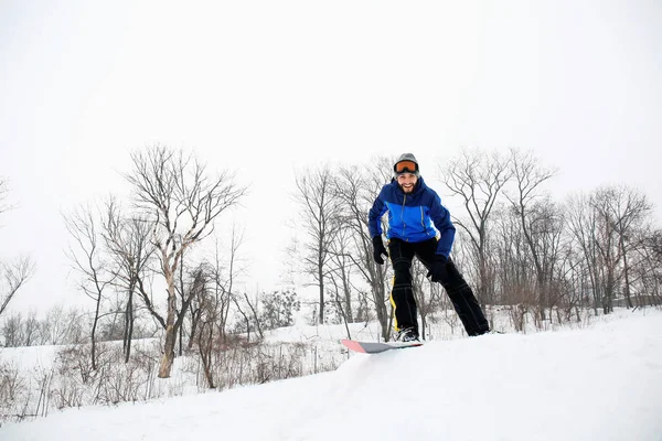 Αρσενικό snowboarder σε πλαγιά στο χειμερινό θέρετρο — Φωτογραφία Αρχείου