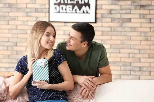 Mujer joven con caja de regalo de su novio en casa — Foto de Stock