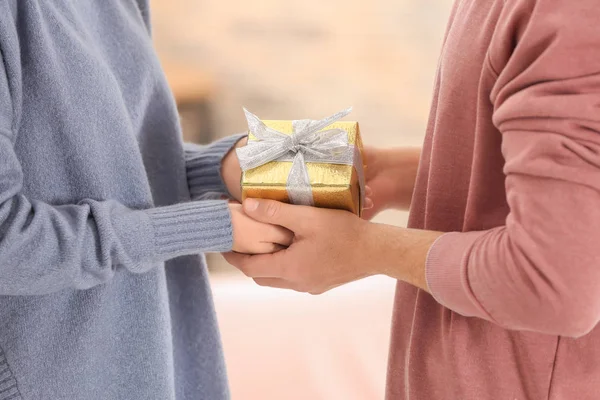 Pareja joven y cariñosa con caja de regalo en casa, primer plano — Foto de Stock