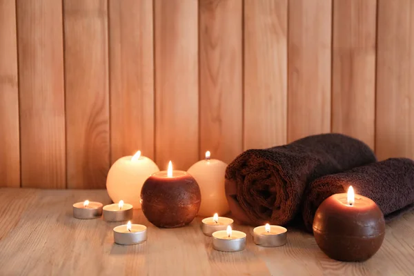 Beautiful burning candles with towels in sauna bath — Stock Photo, Image