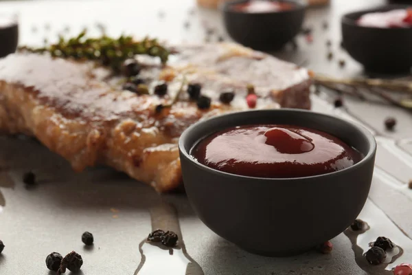 Delicious barbecue sauce in bowl on table