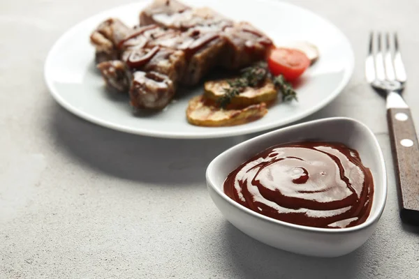 Bowl with delicious barbecue sauce on table — Stock Photo, Image