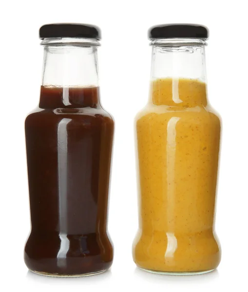 Бутылки с вкусными соусами на белом фоне — стоковое фото