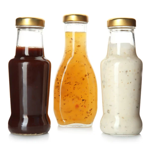 Bouteilles avec de savoureuses sauces sur fond blanc — Photo