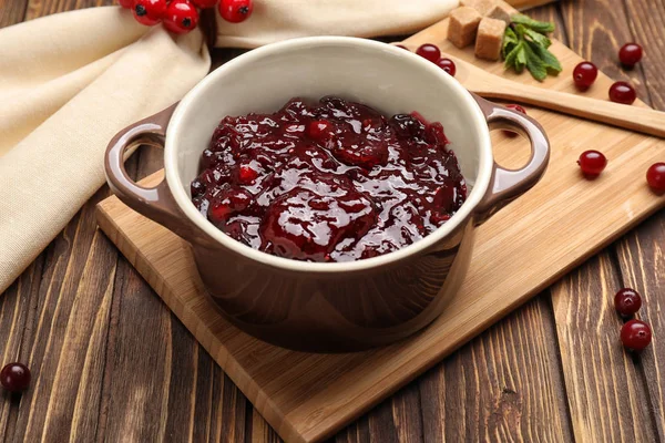 Pot met smakelijke cranberry saus op tafel — Stockfoto