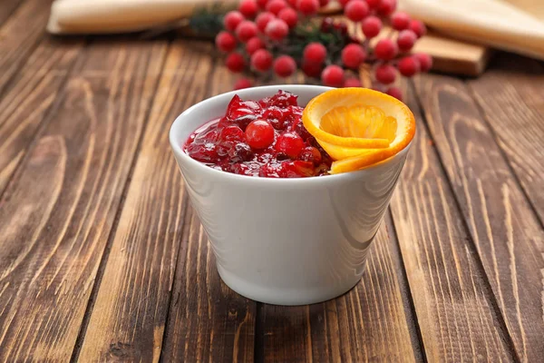 Tigela com molho de cranberry saboroso na mesa — Fotografia de Stock