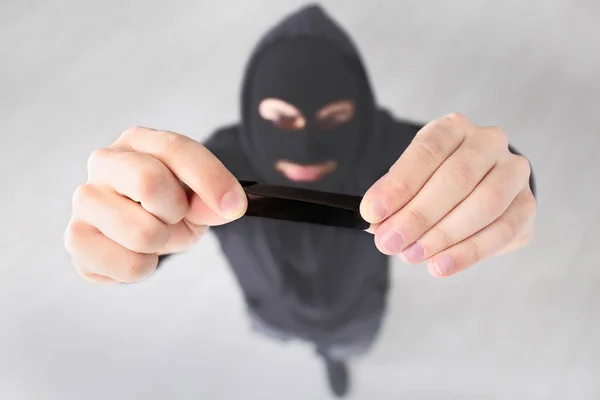 Thief putting sticky tape onto camera of alarm system, indoors — Stock Photo, Image