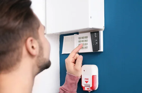 Joven ingresando código en el sistema de alarma de seguridad, en interiores — Foto de Stock