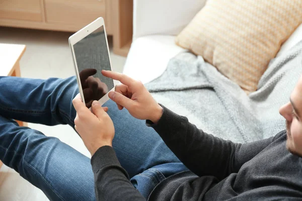 Hombre joven usando la tableta en casa — Foto de Stock