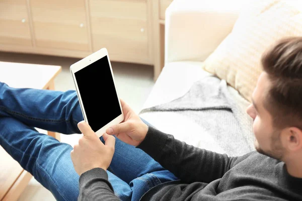 Giovane uomo che utilizza tablet a casa — Foto Stock