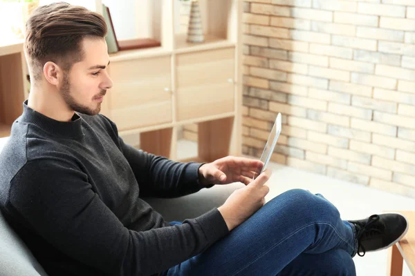 Νεαρός άνδρας χρησιμοποιώντας tablet στο σπίτι — Φωτογραφία Αρχείου