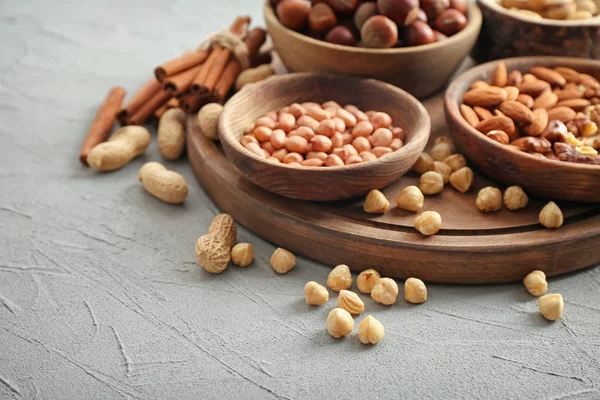 Diferentes tipos de nueces en cuencos en la mesa — Foto de Stock