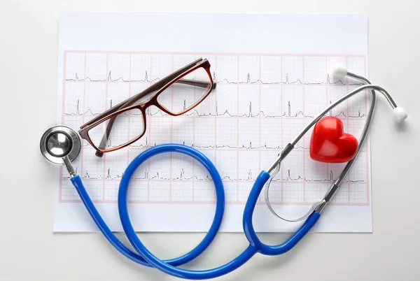 Cardiogram with stethoscope and eyeglasses on white background — Stock Photo, Image