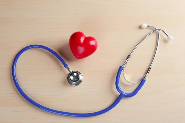 Estetoscopio con pequeño corazón sobre fondo de madera —  Fotos de Stock