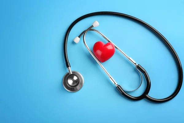 Stetoscopio con piccolo cuore su sfondo a colori — Foto Stock