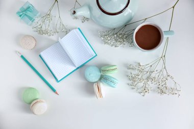 Lezzetli renkli macarons ve beyaz arka plan üzerinde kahve kompozisyonu