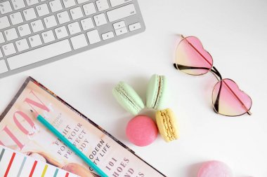 Lezzetli renkli macarons, bilgisayar klavye ve beyaz arka plan üzerinde dergi ile kompozisyon
