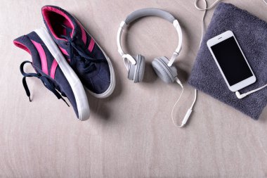 Spor ayakkabı, kulaklık ve gri arka plan üzerinde smartphone ile düz yatıyordu kompozisyon. Jimnastik salonu iş
