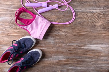 Spor ayakkabıları, spor top ve ahşap arka plan üzerinde ip atlama düz yatıyordu kompozisyonu. Jimnastik salonu iş