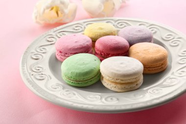 Plaka renk arka plan üzerinde lezzetli macarons ile