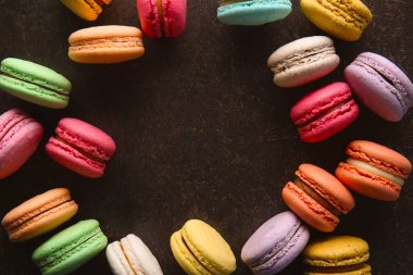 Üstten Görünüm koyu arka plan üzerinde renkli macarons