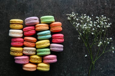 Üstten Görünüm koyu arka plan üzerinde renkli macarons