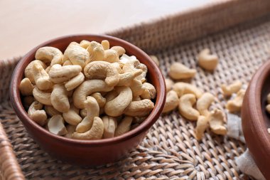 Ahşap masa üzerinde lezzetli kaşu fındık ile kase