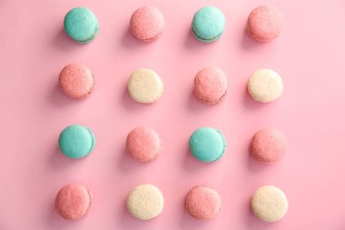 Düz renkli arka plan üzerinde lezzetli macarons yatıyordu