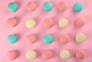 Düz renkli arka plan üzerinde lezzetli macarons yatıyordu