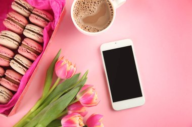 Lezzetli macarons, çiçek, telefon ve kahve renkli arka plan üzerinde kompozisyon