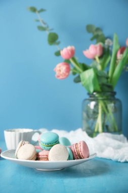 Tablo renkli arka plan üzerinde lezzetli macarons plakalı