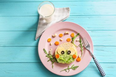Ahşap arka plan, üstten görünüm üzerinde çocuklar için yaratıcı tost ile plaka