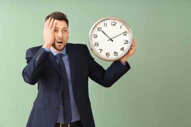 Renk arka plan üzerinde saatli bir iş adamı. Zaman yönetimi kavramı
