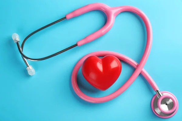 Stethoscope with small heart on color background — Stock Photo, Image