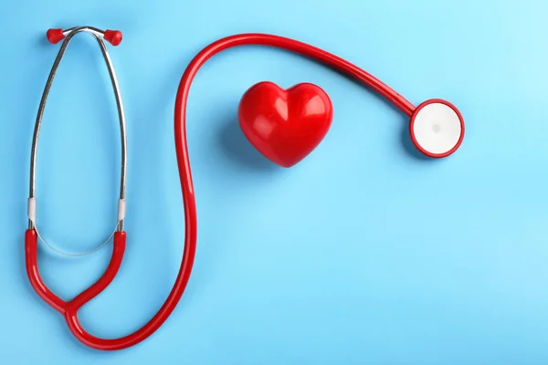 Stetoscopio con piccolo cuore su sfondo a colori — Foto Stock