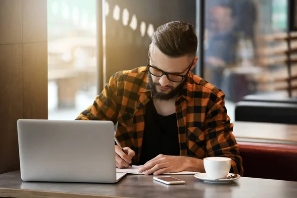 Junge Freiberuflerin mit Laptop arbeitet im Café — Stockfoto