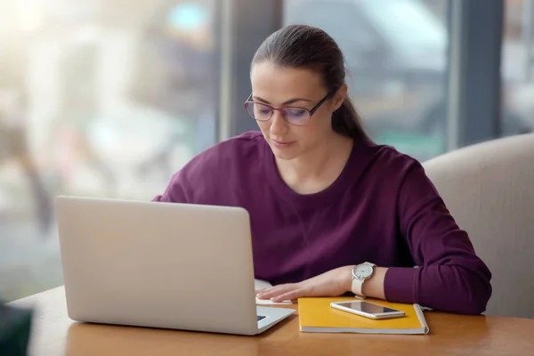 Freelancer jovem com laptop trabalhando no café — Fotografia de Stock