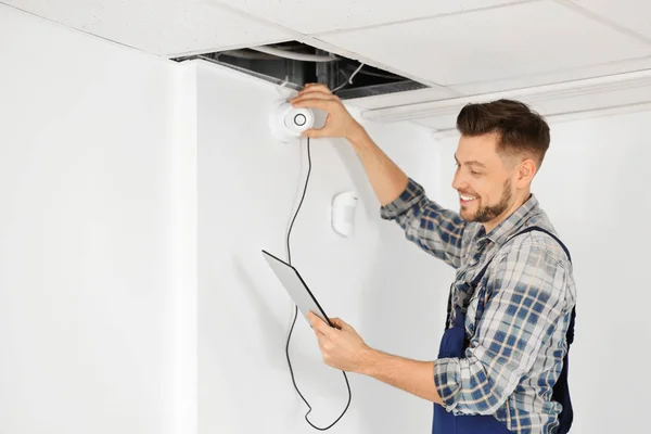 Electrician inspecting surveillance camera — Stock Photo, Image