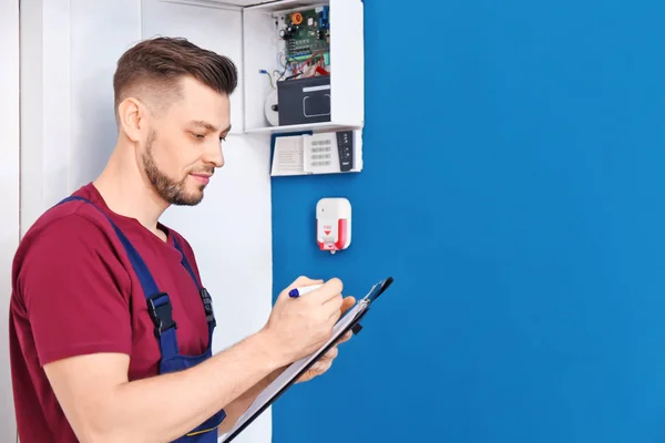 Electricista inspeccionando sistema de alarma —  Fotos de Stock