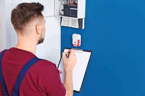 Electrician inspecting alarm system — Stock Photo, Image