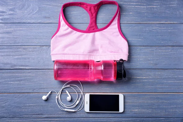 Composición plana con tapa deportiva, botella de agua y smartphone sobre fondo de madera. Entrenamiento en el gimnasio — Foto de Stock