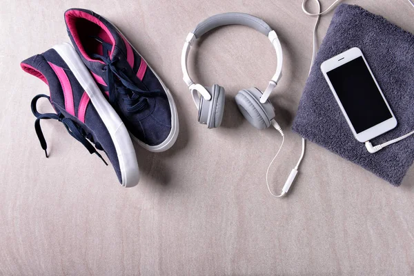 Composición plana con zapatillas, auriculares y smartphone sobre fondo gris. Entrenamiento en el gimnasio — Foto de Stock