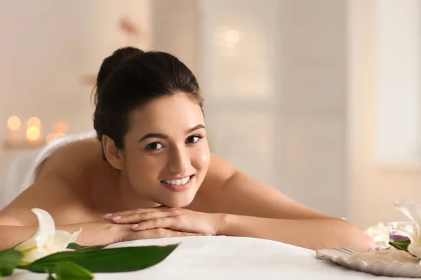 Jeune femme relaxante sur table de massage au salon de spa — Photo