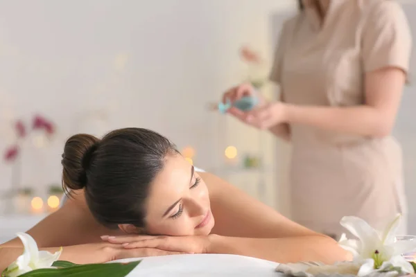 Junge Frau entspannt auf Massagetisch im Wellness-Salon — Stockfoto