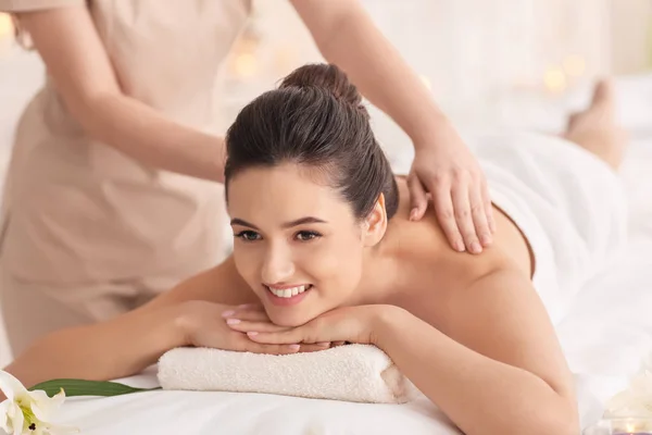 Jonge vrouw ontvangst massage in spa salon — Stockfoto