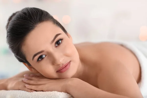 Young woman relaxing on massage table at spa salon — Stock Photo, Image